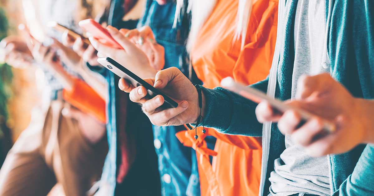 Closeup of many people holding and looking at their mobile phones