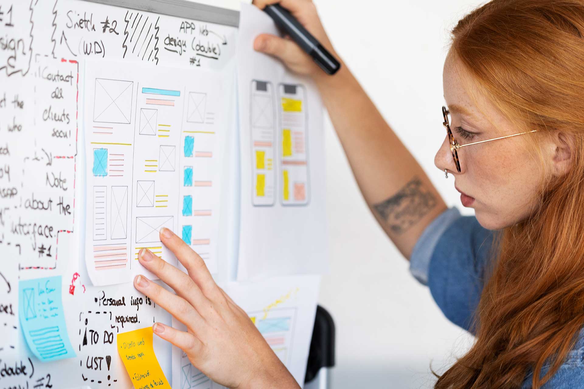 Woman at a whiteboard working on a plan for a website redesign