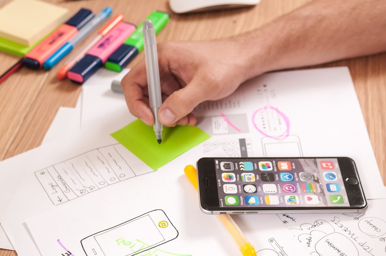 Plans for a mobile website on a table. Persons had writing with a pen on a post0it-note