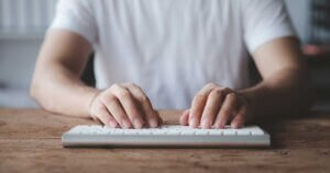 Copywriter typing on a laptop.