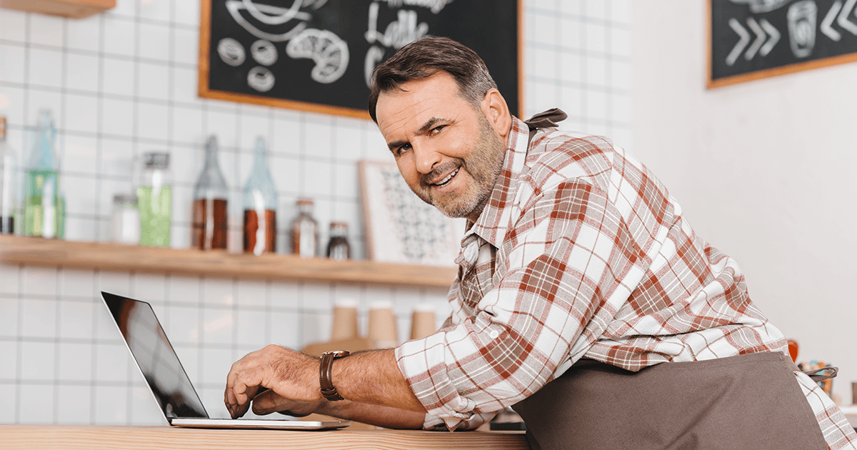 Small business owner looking at his website on laptop.