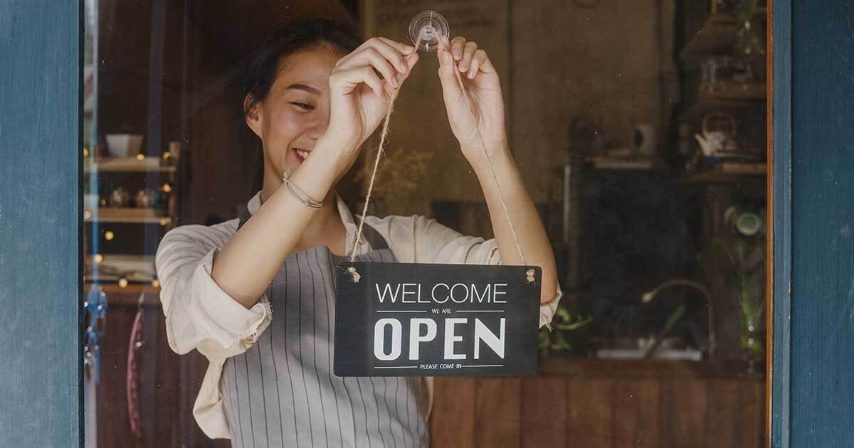 Kent small business owner putting out open sign.
