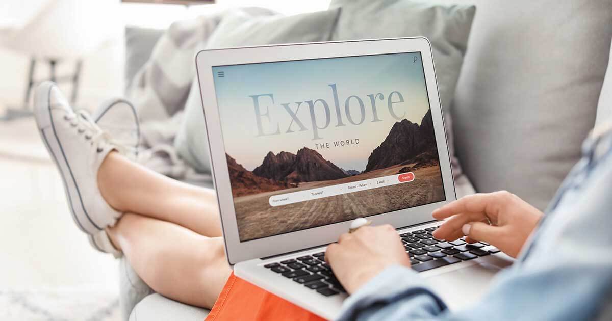 Woman with laptop visiting travel agency website at home