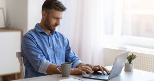 Man searching the internet on laptop.