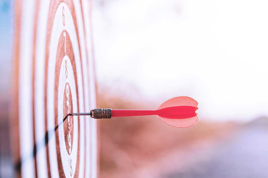 Close up red dart arrow hitting target center dart.